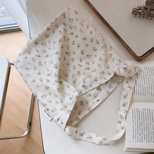 Floral cotton shoulder bag with orange flower patterns on a minimalist aesthetic desk