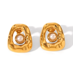Close-up of golden irregular floral frame earrings with central white pearl inlay