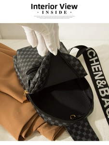 Detail view of crossbody bag's inner compartment with clover pattern and wide logo strap
