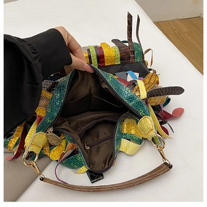 Detailed interior of ethnic fringe handbag showing lining, zipper pocket, and colorful patchwork