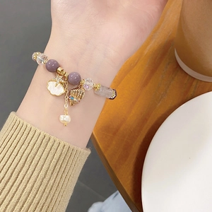Lavender amethyst bead bracelet with golden starfish charms and pearl on a wrist