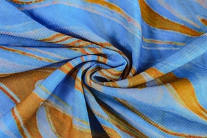 Gros plan sur le tissu en maille bleu ciel et orange montrant la texture et les motifs