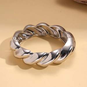 Macro shot of silver metallic twisted rope texture on a wide minimalist cuff bracelet