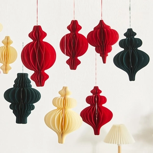 Hanging honeycomb paper lanterns in red, beige, and green for Christmas decor
