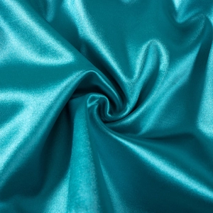 Macro shot of teal satin fabric texture with elegant pleats and smooth silky sheen