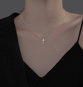Close-up of a minimalist S925 silver cross pendant necklace worn on the collarbone