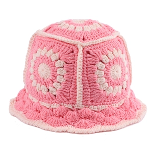 Detailed close-up of handmade crochet flower pattern in pink and cream knitted yarn
