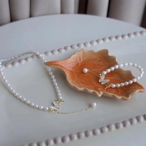 Detail of freshwater pearl necklace set with zircon butterfly pendant and gold OT buckle