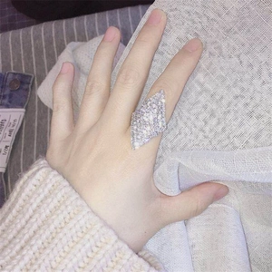 Detailed close-up of a large shield-shaped silver ring with micro-pave crystals on finger