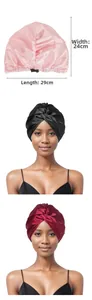 Detail of adjustable satin hair bonnets in pink and black with cross-twist design
