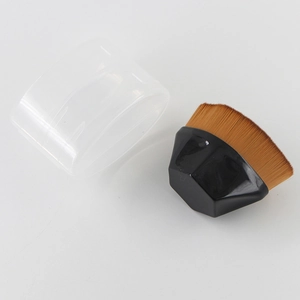 Macro view of portable foundation brush with black handle and transparent storage lid