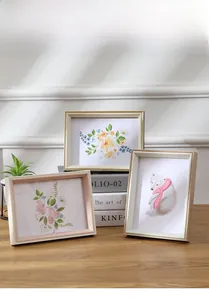 Close-up of Nordic style wooden photo frames in wood, pink and champagne gold tones