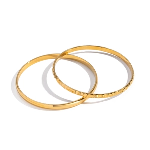 Dettaglio della combinazione di bracciali dorati lisci e martellati per accessori donna