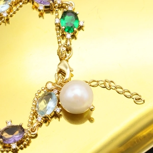 Elegant gold bracelet with colorful gemstones and a large white natural pearl pendant