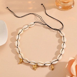 Detail of bohemian shell necklace with gold starfish and moon charms on a woven cord