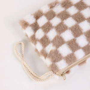Detail of plush checkered makeup bag with soft texture and sturdy metal zipper closure