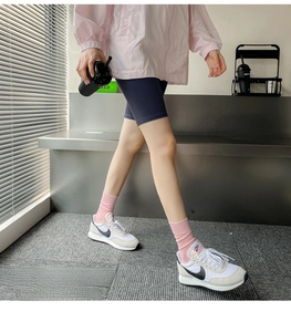 Detail of pink ribbed mid-calf socks styled with sneakers for a casual sporty look