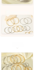 Détail de grandes boucles d'oreilles créoles dorées et argentées sur soie élégante