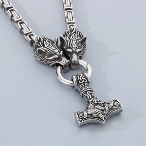 Detail of Viking Thor's Hammer pendant with wolf heads and Celtic knot on steel chain