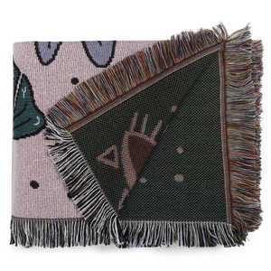 Detail of woven boho blanket featuring cartoon character patterns and multi-color fringe