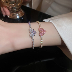 Detail of silver heart tennis bracelet with zircon stones on female wrist in luxury setting