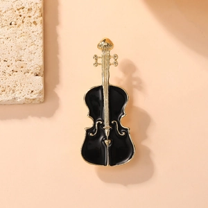 Macro shot of an elegant black enamel cello brooch with gold trim on a natural stone base