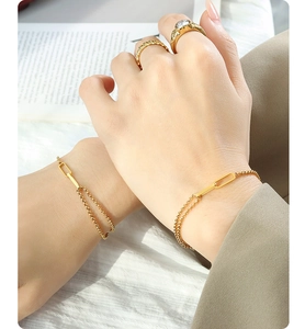 Close-up of minimalist layered 18K gold-plated titanium steel chains on woman's wrist