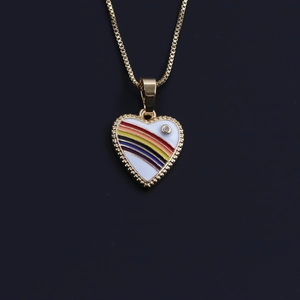 Close-up of golden box chain with a white heart pendant featuring rainbow stripes and a small crystal