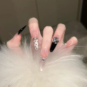 Long almond press-on nails with black French tips, white dots and rhinestone accents
