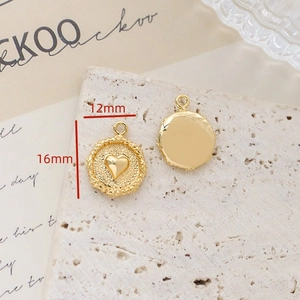 Detail of vintage 18K gold-plated heart charms with radial texture and rope edge