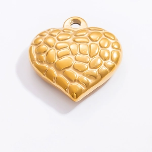 Détail du pendentif coeur en or 18k avec texture martelée unique sur fond blanc neutre