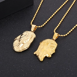 Close-up of two 18K gold plated stainless steel Jesus head pendants with bead chains