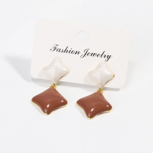 Detail of vintage clover stud earrings with white and brown diamond-shaped resin pendants