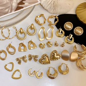 Vielfältiges Set stilvoller goldfarbener geometrischer Ohrringe mit Herz- und Schleifenmotiv