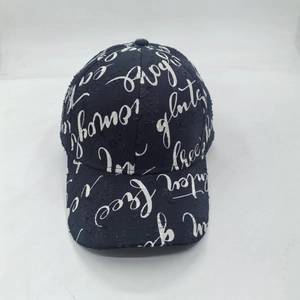 Detailed view of dark baseball cap featuring white street graffiti embroidery and distressed fabric