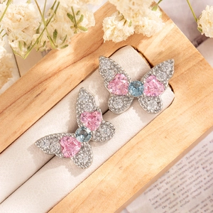 Silver butterfly stud earrings with pink heart crystals and blue gems on display
