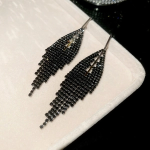 Detailed shot of black rhinestone tassel earrings with leaf-shaped pavé setting