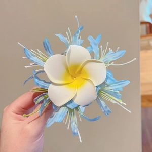 Handgehaltener Haarclip mit weiß-gelber Plumeria und blauen Mesh-Blütenblättern