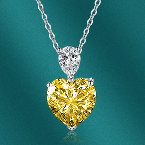 Détail d'un collier en argent avec pierre en poire et pendentif cœur jaune étincelant