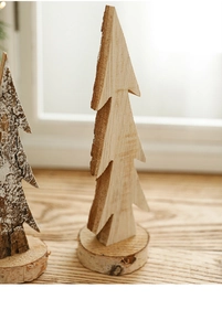 Close-up of wooden Christmas tree ornaments with natural bark edges and snowy white texture