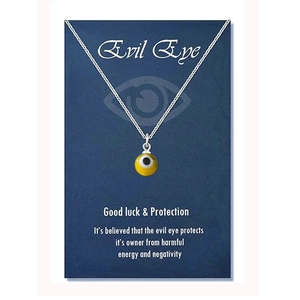 Detail of yellow evil eye charm necklace on blue display card with protective message