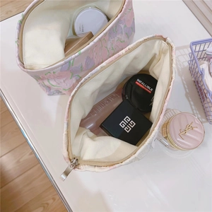 Macro detail of tulip floral textured makeup bag showing spacious interior and secure zipper