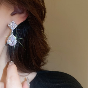 Macro shot of silver drop-shaped zircon earrings with luxury crystal inlay details