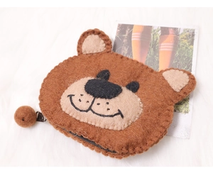 Detail of brown wool felt bear coin purse with zipper closure and fluffy pom pom charm