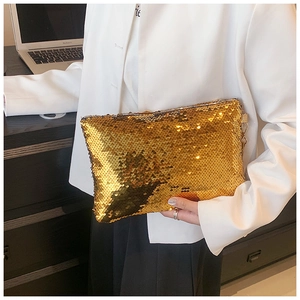 Close-up of golden sequin clutch bag detail with reflective metallic finish