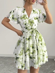 Abito in chiffon bianco e verde con stampa floreale, scollo a V e balze a strati sul fondo