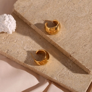 Boucles d'oreilles créoles plaquées or 18 carats sur un support en marbre luxueux