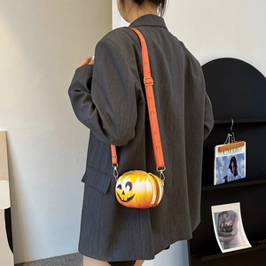 Rear view of a stylish pumpkin-shaped crossbody bag with a wide orange patterned strap