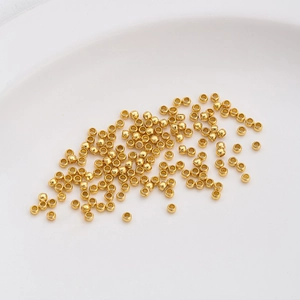 14K gold filled spacer beads for DIY jewelry making displayed on a white plate