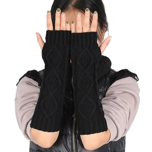 Detail of black diamond-pattern knit long fingerless gloves showing texture and arm sleeve